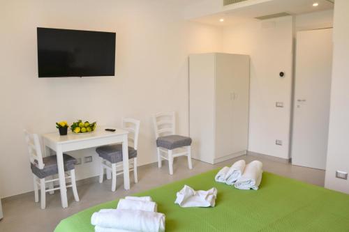 uma sala de estar com uma mesa e um tapete verde em Amalfi Montemare Rooms em Amalfi