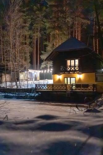 a building with lights on in the snow at night at Ekodom in Voropayev