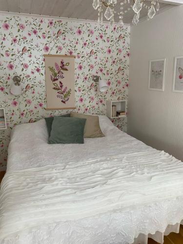 een slaapkamer met een groot bed met bloemenbehang bij Lövlingskulle in Sandöverken