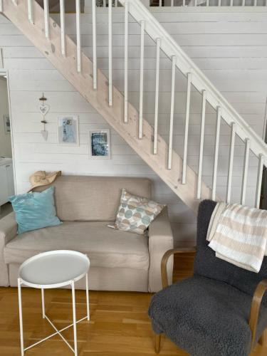 a living room with a couch and stairs at Lövlingskulle in Sandöverken