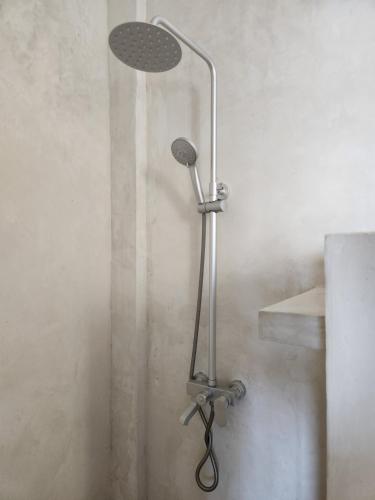 a shower with a shower head in a bathroom at Two Palms in Jambiani