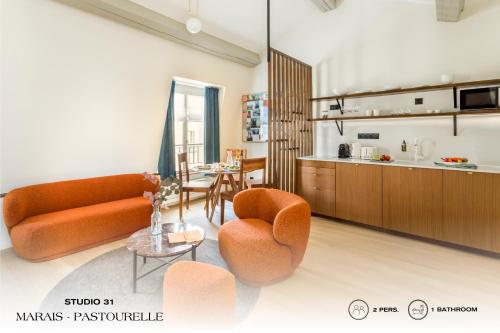 a living room with orange furniture and a kitchen at Beauquartier - Marais, Pastourelle in Paris