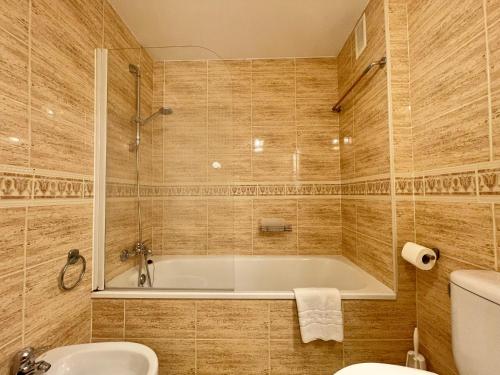 y baño con bañera, aseo y lavamanos. en LaFrenchTouch - Amplio apto con piscina y parking, en Torremolinos