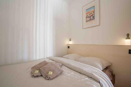 A bed or beds in a room at Petit Cocon avec Vue Dernier Etage - Mazarin 1833