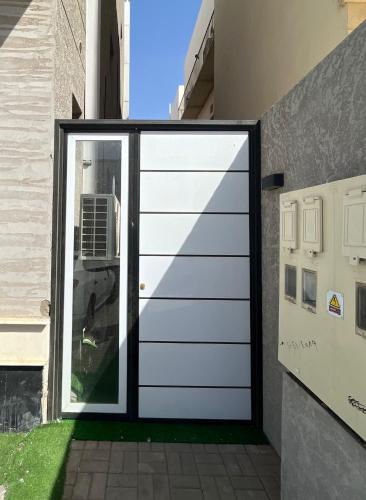 a white garage door in the side of a building at Madinah Valley Residency Kingsize Studio in Sulţānah