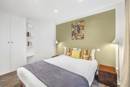 une chambre avec un grand lit blanc dans une pièce dans l'établissement Bella Citta, à Paris