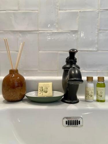 - une étagère avec des bouteilles, un bol et une bougie dans l'établissement Petit Cocon avec Vue Dernier Etage - Mazarin 1833, à Aix-en-Provence