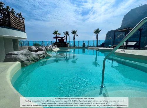 a swimming pool with blue water in a resort at Luxury 1 Bed - City Suites Ocean Spa Plaza in Gibraltar