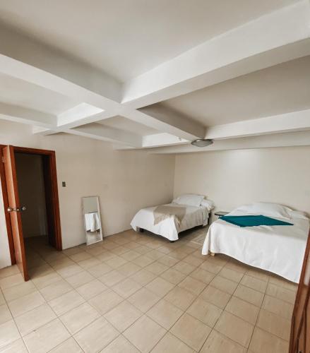um quarto com 2 camas e um tecto em Casa La Cuarta em San Luis Potosí