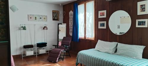1 dormitorio con cama, espejo y sillas en Stasion Di Pueste en Nogaredo