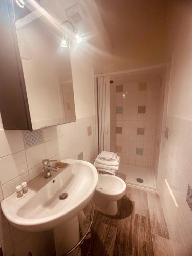 a white bathroom with a sink and a toilet at Corte Perugia in Matino