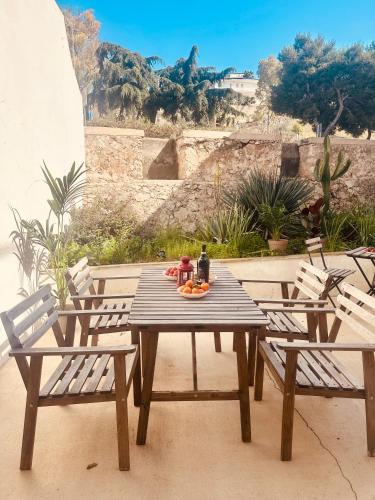 a wooden table with two chairs and a table with fruit at Corte Perugia in Matino