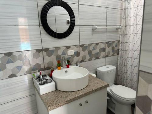 uma casa de banho com um lavatório, um WC e um espelho. em Hermosa casa cerca a Cieneguilla em Huarochirí