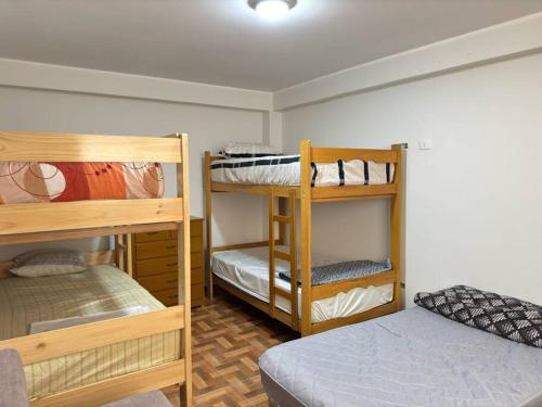 um quarto com três beliches e uma cama em Hermosa casa cerca a Cieneguilla em Huarochirí