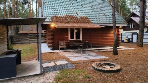 a log cabin with a table and chairs in the yard at Ekodom in Voropayev