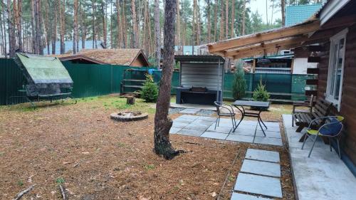 a backyard with a table and chairs and a tree at Ekodom in Voropayev