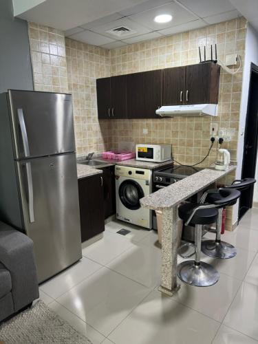 a kitchen with a stainless steel refrigerator and a counter at Studio Apartment near JBR in Dubai