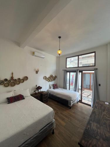 a bedroom with two beds and a large window at MAYAN SURF HOTEL in El Paredón Buena Vista