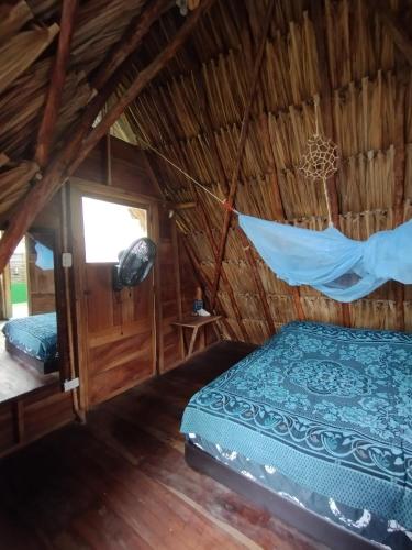 1 dormitorio con 1 cama y 1 hamaca en una habitación en SakaNibue en San Bernardo del Viento