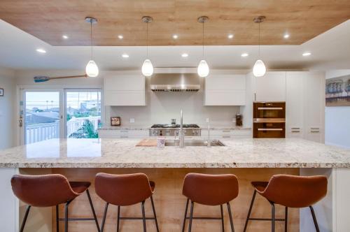 a kitchen with a large island with brown bar stools at Point Loma Serenity in San Diego