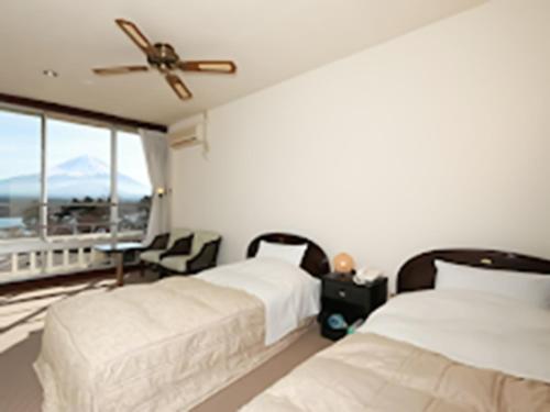 twee bedden in een kamer met uitzicht op een berg bij Shoji Mount Hotel - Vacation STAY 83000v in Narusawa