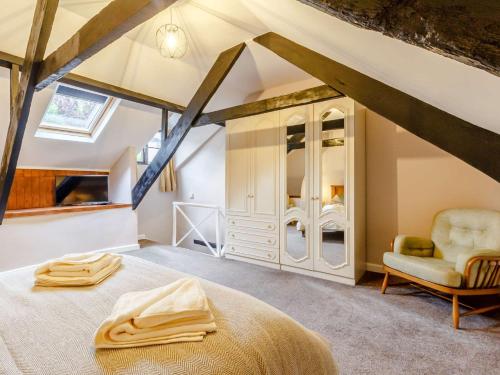 a attic bedroom with a bed and a chair at 4 Bed in Brixham 82519 in Brixham
