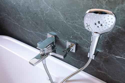 a sink with a faucet next to a bath tub at L'orée de la Forêt in Desvres