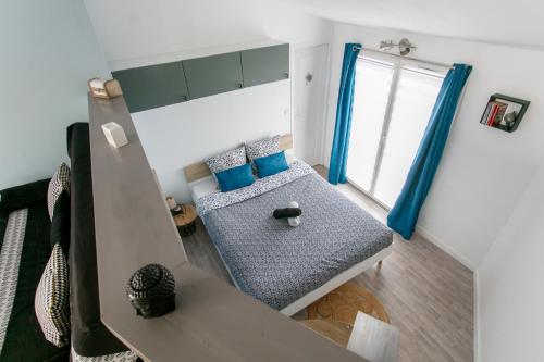 メシェ・シュル・ジロンドにあるJolie maisonnette vue merの青い枕と窓のあるベッドのある寝室