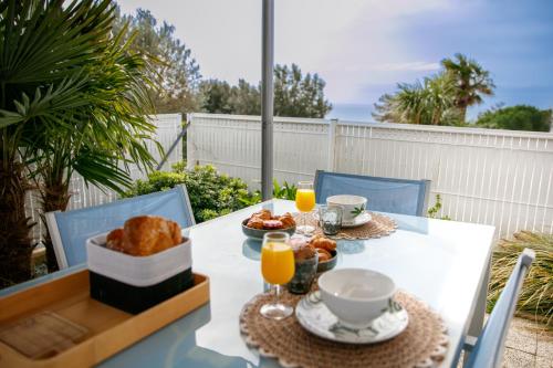 メシェ・シュル・ジロンドにあるJolie maisonnette vue merのパンとオレンジジュースの朝食付きテーブル