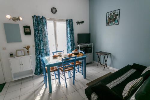 - un salon avec une table bleue et un canapé dans l'établissement Jolie maisonnette vue mer, à Meschers-sur-Gironde