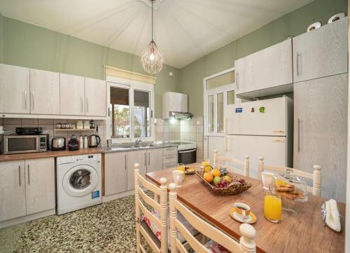 Una cocina con una mesa con un bol de fruta encima. en Veranda Verde in Argostoli, en Argostoli