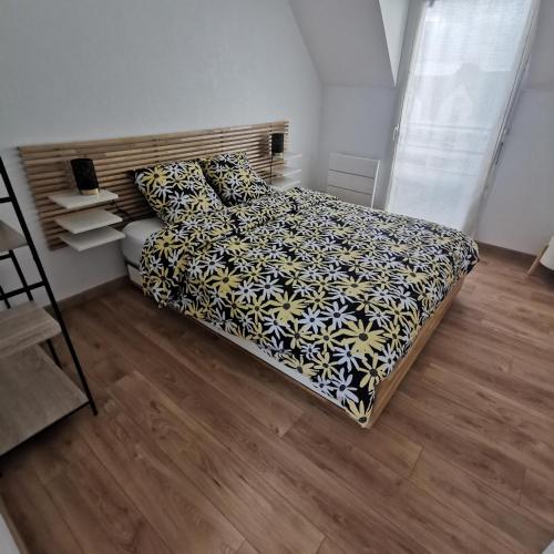 - une chambre avec un lit doté d'une couverture noire et jaune dans l'établissement TYVAC - Maison centre Plougasnou 2 chambres- 4 voyageurs, à Plougasnou