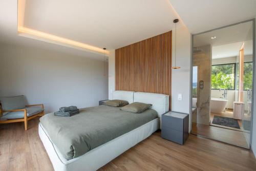 une chambre avec un grand lit et une baignoire dans l'établissement VILLA ELSA, Golfe de Saint Tropez, sublime vue mer, à Grimaud