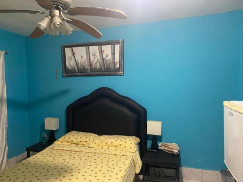 a bedroom with a bed with a blue wall at Recamara a media cuadra de la playa in Mazatlán