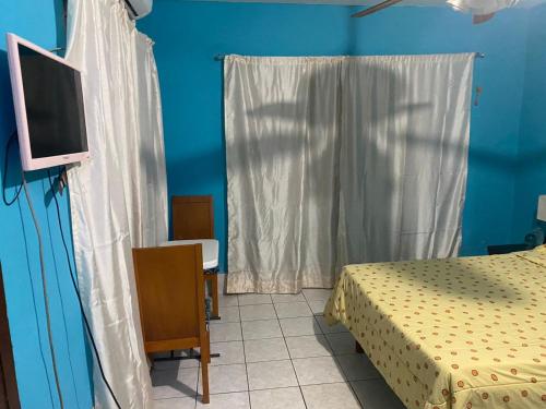 a bedroom with a bed and a tv and a window at Recamara a media cuadra de la playa in Mazatlán