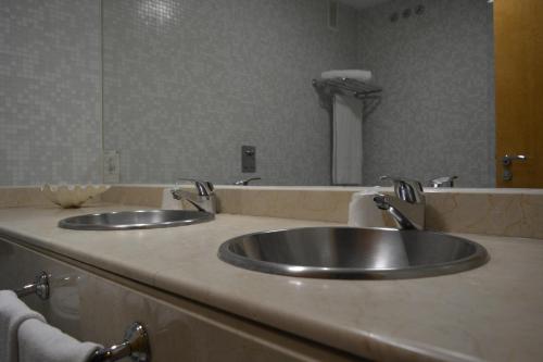 a bathroom with two sinks and a large mirror at Ruta Jacobea in Lavacolla