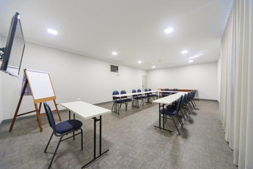a room with tables and chairs and a painting at Realce Hotel in Jaú