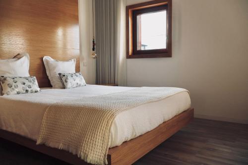1 dormitorio con cama con almohadas y ventana en Casa Das Chães, en Caniçada