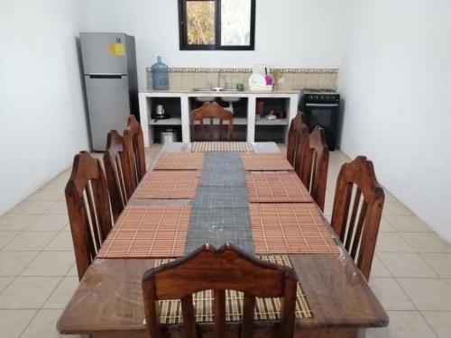 cocina con mesa larga con sillas y nevera en Casa 2 Salinas Monterrico completamente equipada y con piscina privada, en Monterrico