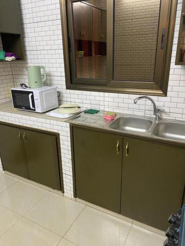 a kitchen counter with a sink and a microwave at MYKONOS in Ouagadougou