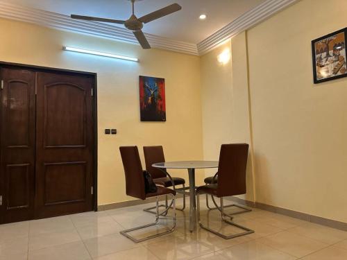 a dining room with a table and chairs and a ceiling fan at MYKONOS in Ouagadougou