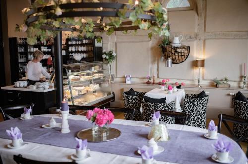 a restaurant with tables and a woman preparing food at Remise 2 in Neustadt in Holstein