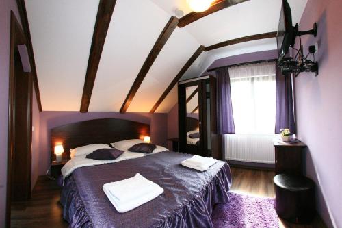 - une chambre avec un grand lit dans l'établissement Vila Romanita, à Păltiniş
