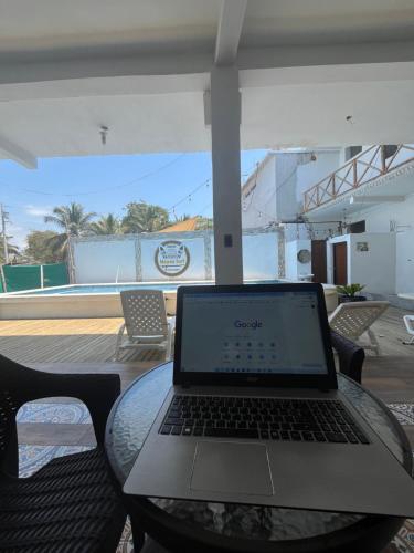 un ordinateur portable assis sur une table en verre sur une terrasse dans l'établissement MAYAN SURF HOTEL, à El Paredón Buena Vista