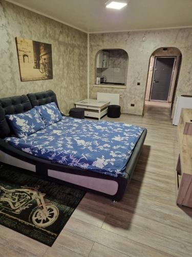 a bedroom with a bed with a blue comforter at Cornelius Studio in Galaţi