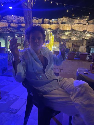 a woman sitting in a chair in a room with a view at Mirvana Guest House & Camel safari in Jaisalmer