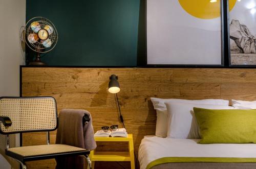 a bedroom with a bed and a chair and a lamp at Dizengoff square boutique - aparthotel in Tel Aviv
