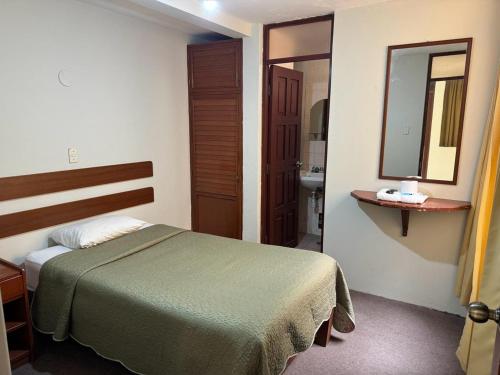 a hotel room with a bed and a mirror at Hotel Los Angeles in Arequipa