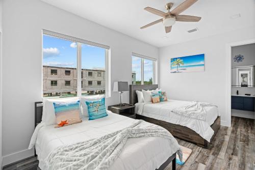 a bedroom with two beds and a ceiling fan at Luna Light ~ Waterfront ~ Pool ~ Dock ~ Views in Marathon