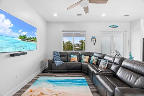 a leather couch in a living room with a view of the ocean at Luna Light ~ Waterfront ~ Pool ~ Dock ~ Views in Marathon